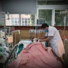 Bác sỹ thăm khám cho bệnh nhân ngộ độc rượu đang điều trị tại Trung tâm Chống độc. (Ảnh: PV/Vietnam+)