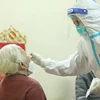 Nhân viên y tế lấy mẫu xét nghiệm cho người dân. (Ảnh: TTXVN/Vietnam+)