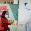 Nhân viên y tế hỗ trợ người nhiễm COVID-19 thể nhẹ tại thành phố Vĩnh Yên. (Ảnh: TTXVN phát)