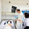 Bác sỹ thăm khám cho bệnh nhân đang điều trị tại bệnh viện. (Ảnh: PV/Vietnam+)