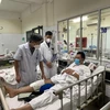 Phó giáo sư Nguyễn Mạnh Khánh khám cho bệnh nhân T. sau phẫu thuật. (Ảnh: PV/Vietnam+)