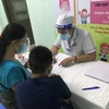 Bác sỹ thăm khám cho trẻ em đến khám. (Ảnh: PV/Vietnam+)