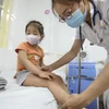 Bác sỹ khám cho bệnh nhi sốt xuất huyết tại bệnh viện Thanh Nhàn. (Ảnh: Minh Quyết/TTXVN)