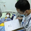 Bác sỹ thăm khám cho bệnh nhân sốt xuất huyết đang điều trị tại Bệnh viện đa khoa Đống Đa, Hà Nội. (Ảnh: Minh Quyết/TTXVN)