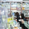 Người dân tới mua thuốc tại một cửa hàng thuốc ở Hà Nội. (Ảnh: TTXVN/Vietnam+)