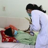 Bác sỹ Bệnh viện Đa khoa tỉnh Vĩnh Long thăm khám cho bệnh nhân sốt xuất huyết. (Ảnh: Lê Thúy Hằng/TTXVN)