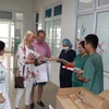 Cặp vợ chồng người Anh xúc động và vui mừng khi được gặp và tặng sách cho các y bác sỹ. (Ảnh: PV/Vietnam+)
