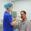 Nhân viên y tế chăm sóc cho bệnh nhân sau phẫu thuật. (Ảnh: PV/Vietnam+)