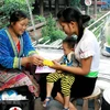 Cô đỡ thôn bản chăm sóc sức khoẻ bà mẹ, trẻ em tại huyện Mường Nhé (Điện Biên). (Ảnh: Dương Ngọc/TTXVN)