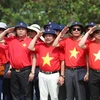 Bà con Kiều bào cùng các đại biểu làm lễ chào cờ tại đảo Trường Sa. (Ảnh: Hồng Sơn/Vietnam+)