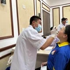 Nhân viên y tế xét nghiệm COVID-19 cho người dân. (Ảnh: Thùy Giang/Vietnam+)