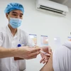 Nhân viên y tế Bệnh viện Hữu nghị Việt Xô tiêm vaccine phòng COVID-19 cho người dân. (Ảnh: Minh Sơn/Vietnam+)