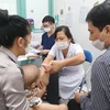Tiến sỹ Nguyễn Việt Hoa khám cho một trẻ trong chương trình. (Ảnh: PV/Vietnam+)