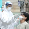 Nhân viên y tế lấy mẫu xét nghiệm COVID-19 cho người dân. (Ảnh: TTXVN/Vietnam+)