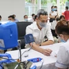 Theo dõi tình hình sức khỏe của người dân trước khi tiêm vaccine COVID-19. (Ảnh: PV/Vietnam+)