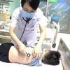 Bác sỹ khám cho một trẻ bị viêm phổi do Mycoplasma. (Ảnh: PV/Vietnam+)