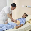Phó giáo sư Nguyễn Anh Tuấn khám cho bệnh nhân sau phẫu thuật. (Ảnh: PV/Vietnam+)