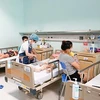 Nhân viên y tế tại Bệnh viện Nhi Trung ương chăm sóc cho trẻ mắc bệnh truyền nhiễm. (Ảnh: PV/Vietnam+)