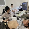 Nhân viên y tế thực hiện siêu âm ổ bụng cho một bệnh nhân. (Ảnh: PV/Vietnam+)