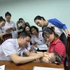 Bác sỹ Bệnh viện Nhi Trung ương khám cho trẻ bị dị tật khe hở môi-vòm miệng. (Ảnh: T.G/Vietnam+)