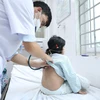 Bác sỹ khám cho bệnh nhi mắc sốt xuất huyết. (Ảnh: PV/Vietnam+)