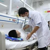 Bác sỹ tại Bệnh viện Xanh Pôn khám cho một bệnh nhi mắc sốt xuất huyết trong tình trạng nặng. (Ảnh: PV/Vietnam+)