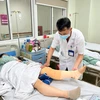 Bác sỹ chăm sóc cho bệnh nhân sau phẫu thuật. (Ảnh: PV/Vietnam+)
