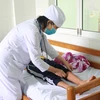 Bác sỹ kiểm tra các điểm phát ban đỏ của bệnh nhân khi mắc sốt xuất huyết tại Bệnh viện Bệnh Nhiệt đới Khánh Hòa. (Ảnh: Phan Sáu/TTXVN)