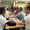 Nhân viên y tế đo huyết áp cho người dân. (Ảnh: T.G/Vietnam+)