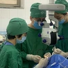 Các bác sỹ Bệnh viện Mắt Trung ương thực hiện ca ghép giác mạc cho bệnh nhân. (Ảnh: PV/Vietnam+)