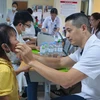 Bác sỹ khám cho trẻ mắc dị tật khe hở môi, vòm miệng. (Ảnh: PV/Vietnam+)