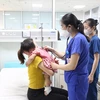 Bác sỹ kiểm tra sức khỏe cho bé gái sau khi đã gắp dị vật ra khỏi dạ dày. (Ảnh: PV/Vietnam+)