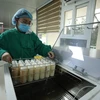 Cán bộ Ngân hàng sữa mẹ Bệnh viện Sản Nhi Quảng Ninh giới thiệu về quy trình thanh trùng sữa mẹ. (Ảnh: PV/Vietnam+)