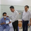 Tổng Giám đốc Bảo hiểm Xã hội Việt Nam Nguyễn Thế Mạnh tặng thẻ Bảo hiểm Y tế cho người dân. (Ảnh: PV/Vietnam+)
