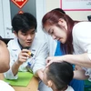 Bác sĩ Bệnh viện E thăm khám cho trẻ mắc dị tật khe hở môi, vòm miệng. (Ảnh: PV/Vietnam+)