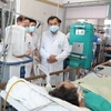 Thứ trưởng Bộ Y tế Trần Văn Thuấn thăm nạn nhân nặng nhất của vụ cháy nhà trọ đang điều trị tại Trung tâm Hồi sức, Bệnh viện Bạch Mai. (Ảnh: PV/Vietnam+)