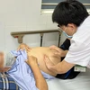 Bác sĩ Điền thăm khám cho nam bệnh nhân. (Ảnh: PV/Vietnam+)
