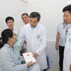 Thứ trưởng Bộ Y tế Trần Văn Thuấn đã thăm hỏi, tặng quà động viên nạn nhân trong vụ cháy ở Trung Kính. (Ảnh: PV/Vietnam+)