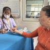 Nhân viên y tế theo dõi, kiểm tra các chỉ số đường huyết cho người dân. (Ảnh: T.G/Vietnam+)