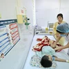 Nhân viên y tế theo dõi sức khoẻ cho trẻ mắc bệnh sốt xuất huyết tại Hà Nội. (Ảnh: Minh Quyết/TTXVN)