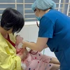 Bác sĩ theo dõi sức khỏe cho một trẻ sơ sinh mắc thủy đậu. (Ảnh: PV/Vietnam+)
