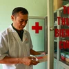 Thiếu tá, bác sĩ quân y Nguyễn Bá Lương lấy thuốc cấp phát cho người dân. (Ảnh: Hoài Nam/Vietnam+)