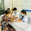 Các bác sỹ khám bệnh cho người dân trong các chương trình tri ân dịp tháng Bảy. (Ảnh: PV/Vietnam+)