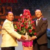 Bộ trưởng An ninh Lào Somkeo Silavong (trái) tặng hoa chúc mừng Cơ quan Đại diện Bộ Công an Việt Nam tại Lào. (Ảnh: Phạm Kiên/TTXVN)