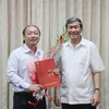 Ông Đinh Thế Huynh trao quyết định và tặng hoa chúc mừng ông Võ Văn Phuông. (Nguồn: tuyengiao.vn)
