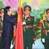 Chủ tịch nước Trương Tấn Sang gắn Huân chương Quân Công hạng Nhất lên Cờ truyền thống của Bộ Tổng tham mưu Quân đội nhân dân Việt Nam. (Ảnh: Nguyễn Khang /TTXVN) 