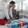 Bác sỹ bệnh viện Nhi Đồng 1 thăm khám cho bệnh nhi bị sốt xuất huyết. (Ảnh: Phương Vy/TTXVN)