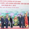 Thường trực Ban Bí thư Lê Hồng Anh gắn Huân chương Hồ Chí Minh lên Cờ truyền thống của Ban Dân vận Trung ương. (Ảnh: Phương Hoa/TTXVN)