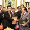 Phó Thủ tướng Phạm Bình Minh (trái) trao đổi Biên bản Thỏa thuận của Kỳ họp thứ 13 với Phó Thủ tướng Campuchia Hor Namhong. (Ảnh: Xuân Khu/TTXVN)