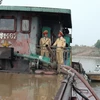 Lực lượng Cảnh sát giao thông đường thủy-Công an tỉnh Bắc Ninh bắt giữ tàu BKS HD-0612 khai thác cát sỏi trái phép trên sông Đuống. (Ảnh: Thái Hùng/TTXVN)